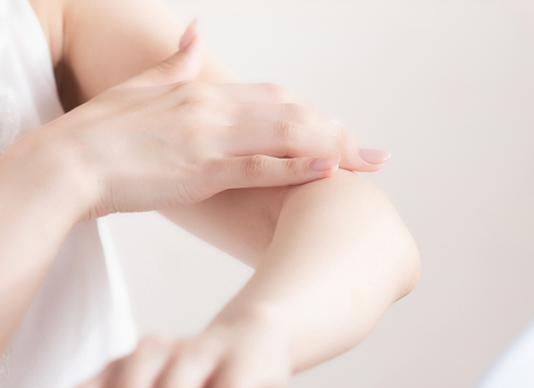 皮膚科の診察で肌の状態をチェックする医師